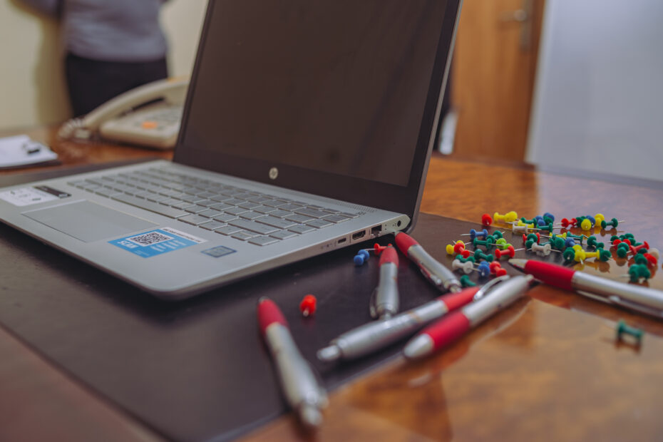 computer with pens and tacks