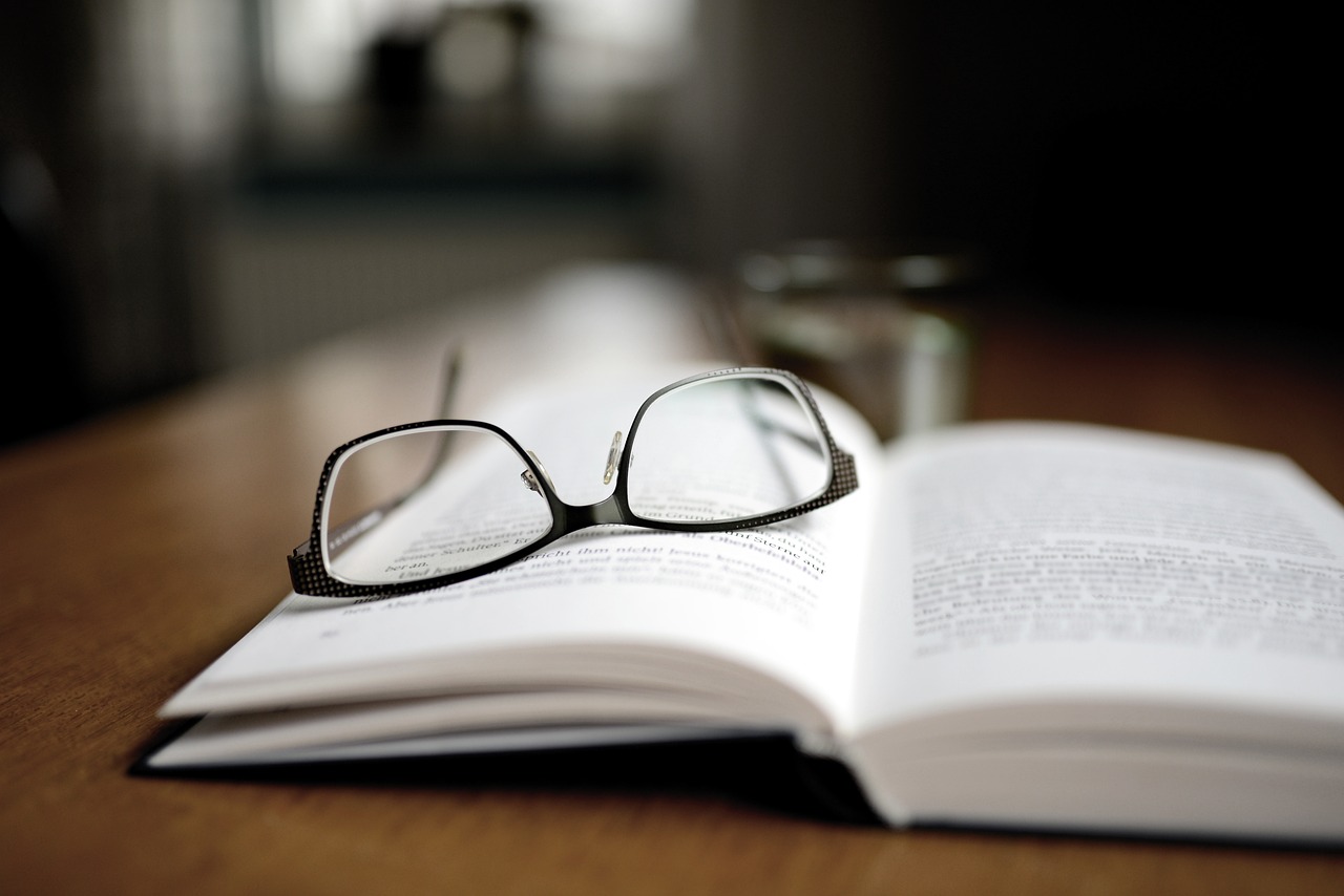 Slvr Wlf Insights A book and glasses showing how important it is to research before writing case studies.